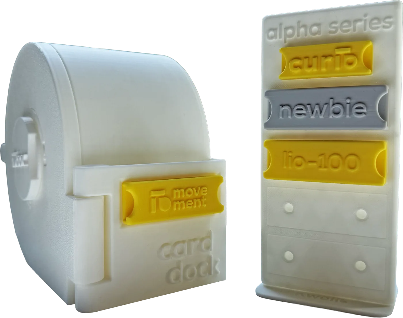 A prototype LioBox with a badge in the card dock on its front, beside a rack of sample badges